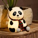 Sitting panda night light with red-green scarf glowing warmly