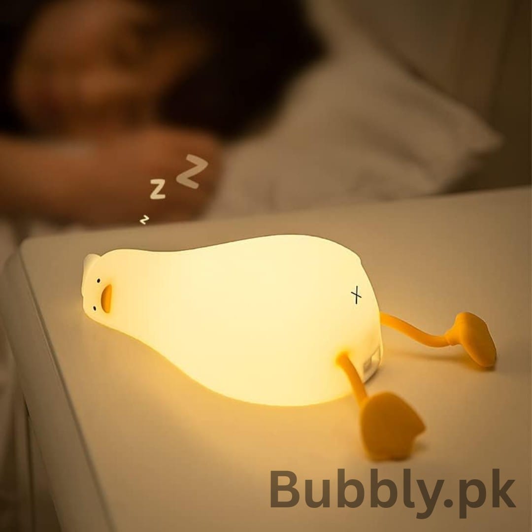 Soft silicone duck night light glowing on bookshelf