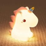 Silicone unicorn clapping lamp glowing on coral base