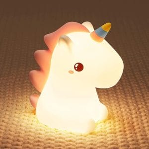 Silicone unicorn clapping lamp glowing on coral base